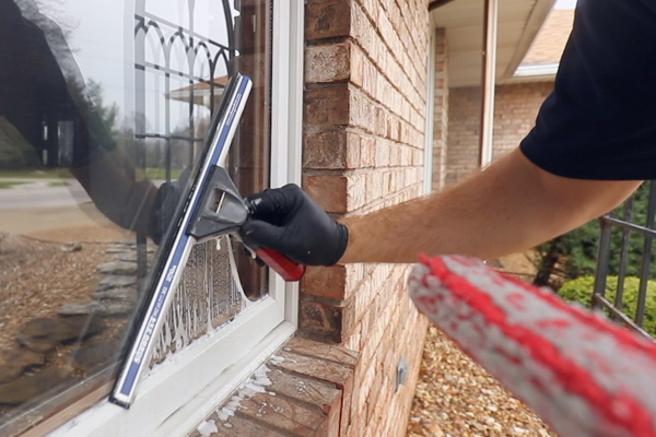 Window cleaning professional using squeegee