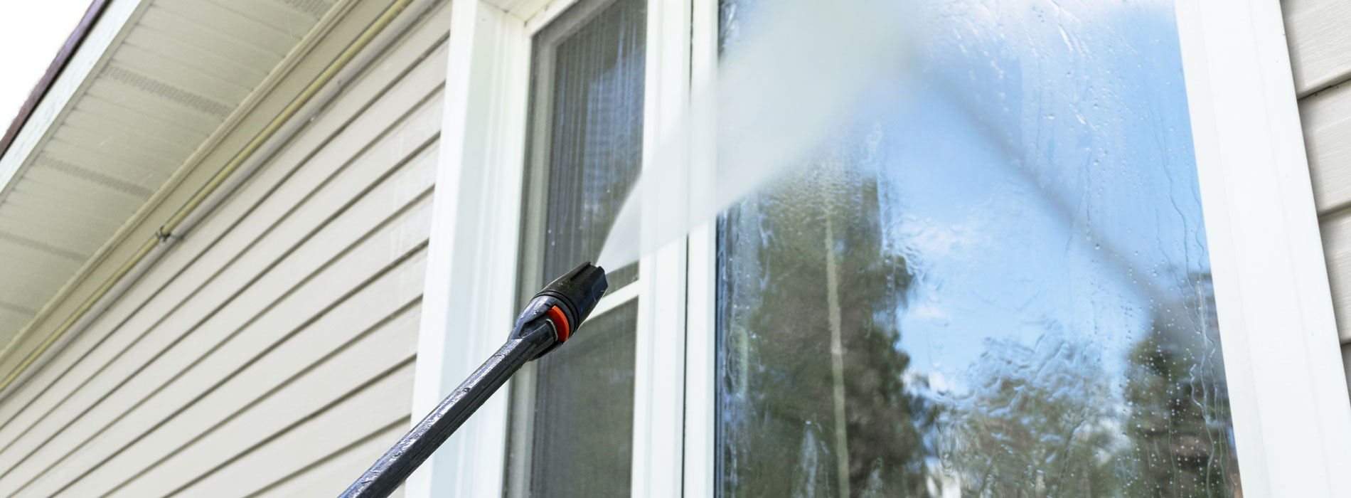 sprayer washing windows on home